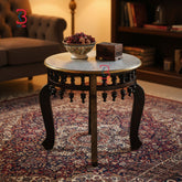 Decorative round table with a bowl and box on a patterned rug in a room.