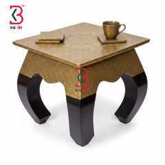 High-angle studio isolation view of the artisan wood stool with embossed golden brass cladding and broad dark espresso arched cabriole legs on a clean white background.