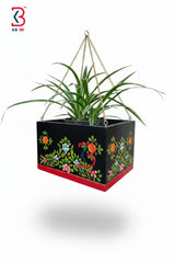 Decorative hanging planter with floral patterns on a white background
