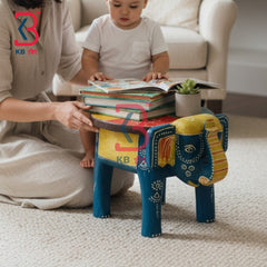 Wooden Elephant Stool KB-5114: A colorful elephant-shaped wooden stool in blue, yellow, and red, styled in a cozy living room setting with a child sitting on it reading