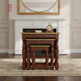 Three multi-size brass-fitted wooden side tables arranged in a staggered step formation to highlight their graduating heights.
