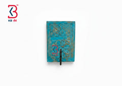 A square turquoise blue textured wall art piece with a black hook at the bottom center, shown against a plain white background. A red and blue KB Art logo watermark is visible in the top-left corner.