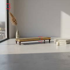 Minimalist interior with a wooden table, vase with dried plants, and candles on a light gray floor.