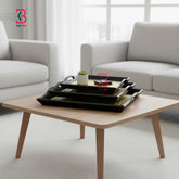 Wooden coffee table with black trays in a living room setting