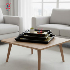 Wooden coffee table with black trays in a living room setting