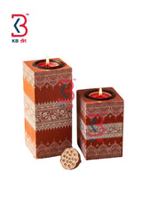 Real product photograph on a white background showing a set of 2 terracotta orange hand-painted wooden rectangular pillar tea-light holders by KB Art.