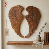 Wooden angel wings wall decor with a shelf and decorative items on a neutral background