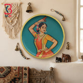 Round wooden wall plate with hand-painted Bharatanatyam classical dancer in orange saree on turquoise background with gold rim