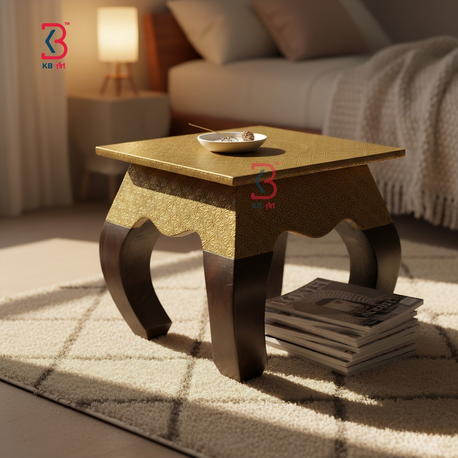 Gold coffee table in a living room setting with a stack of books and a bowl on top.