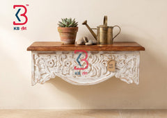 A KB ART ornate wall shelf mounted in a welcoming entryway hall holding keys, a small vase, and displayed beneath a decorative mirror.