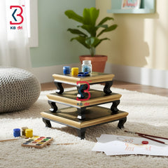 Three-tier wooden stand with art supplies on a carpeted floor, KB Art logo visible.