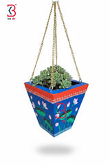 Decorative hanging planter with a colorful design and succulents on a white background
