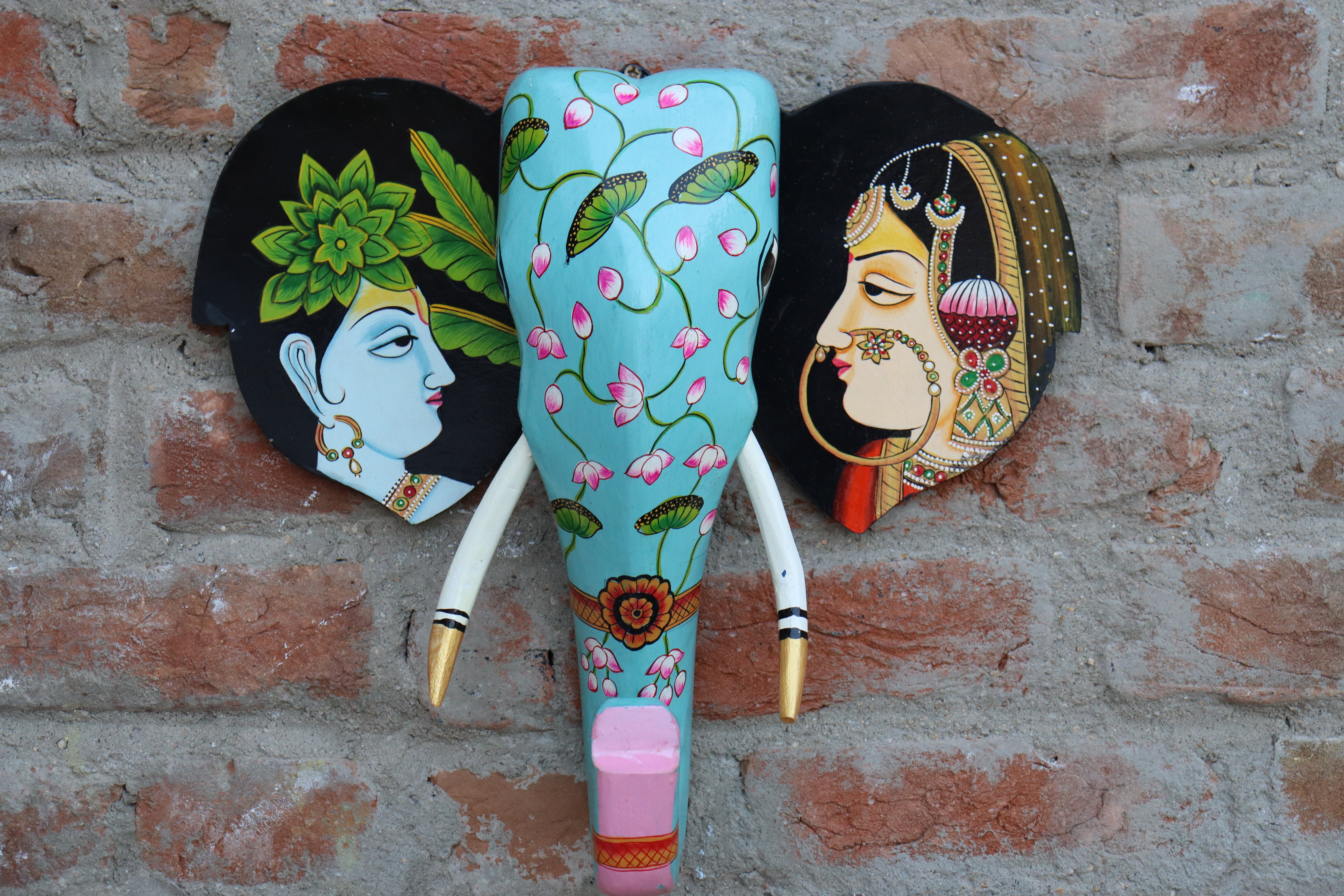 Handmade Indian elephant head decor with a detailed trunk and side portraits, perfect for a gallery wall.