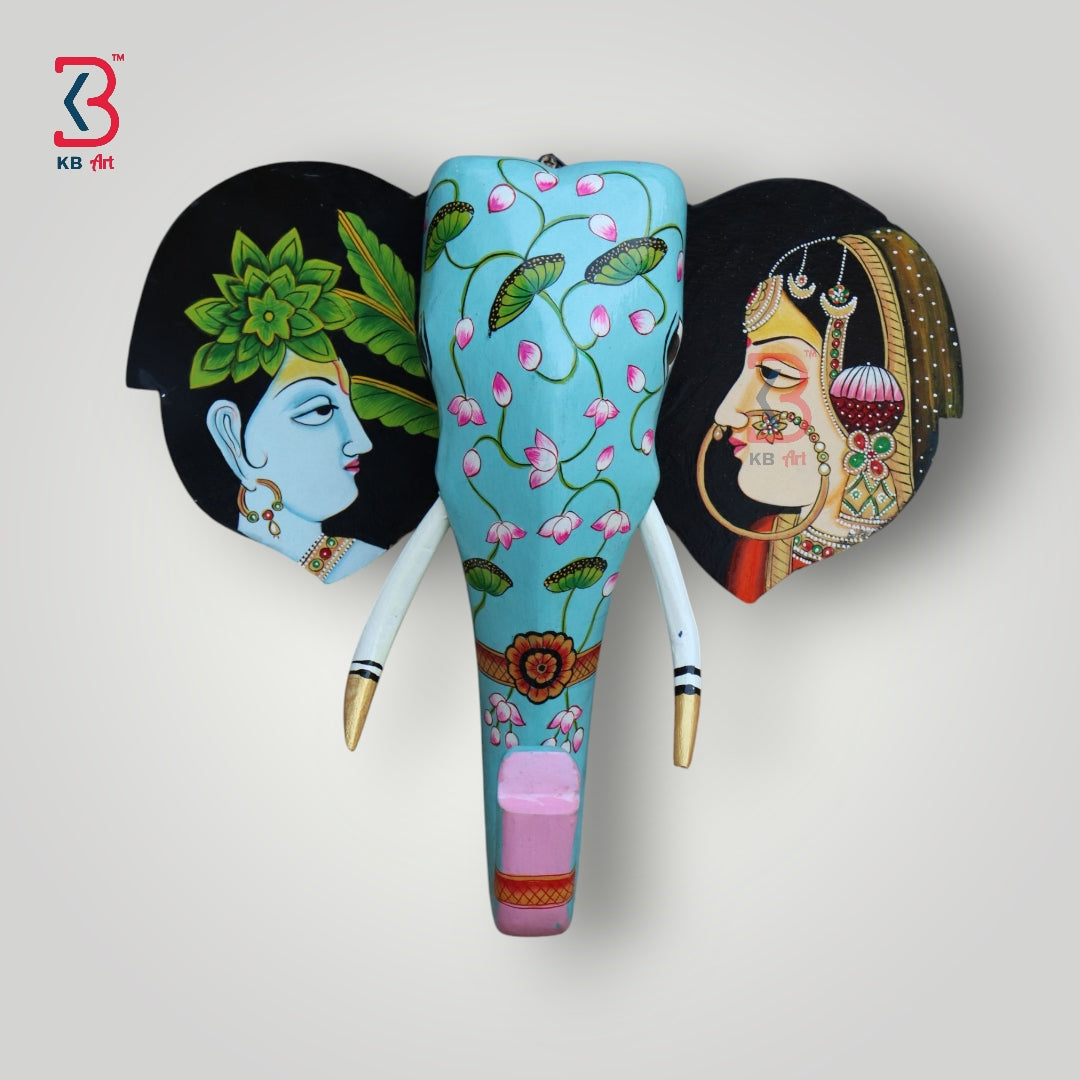 Hand-painted wooden elephant head wall hanging with a turquoise trunk and artistic Indian figures on the ears.