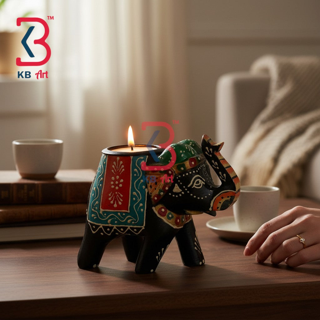A decorative elephant-shaped candle holder with a lit tealight candle, placed on a wooden table in a cozy indoor setting. The elephant is painted black with colorful red, green, and gold patterns.