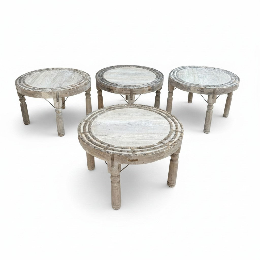 Four round wooden tables with distressed light gray painted finishes, arranged on a clean white background.