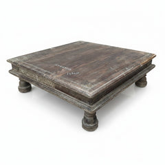 A square, low wooden coffee table with a distressed dark brown finish and turned legs, photographed on a white background.