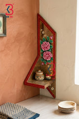 Decorative wall shelf with floral design against a beige wall.