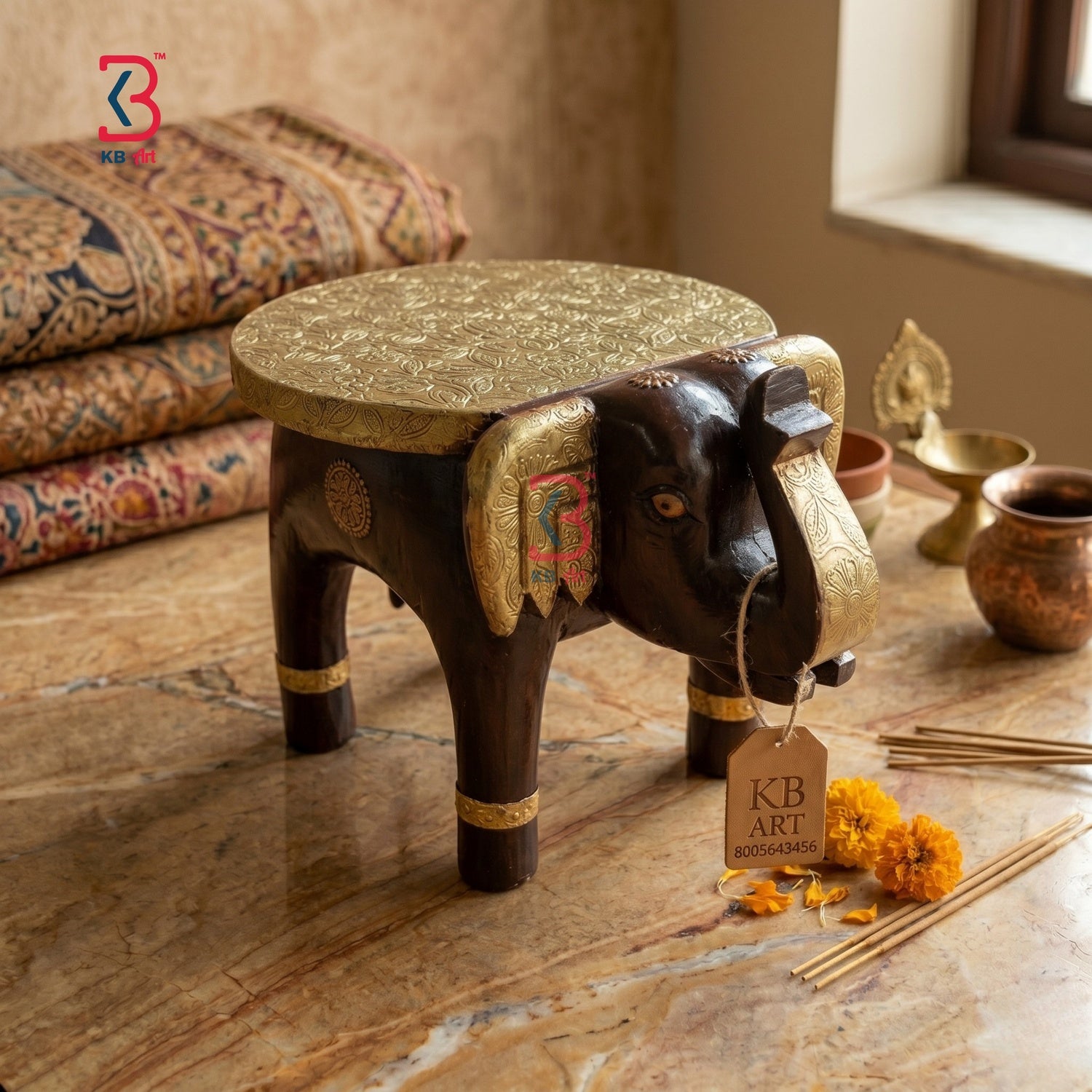 Decorative elephant stool with gold accents on a marble surface, branded 'KB Art'.