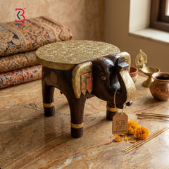 Decorative elephant stool with gold accents on a marble surface, branded 'KB Art'.