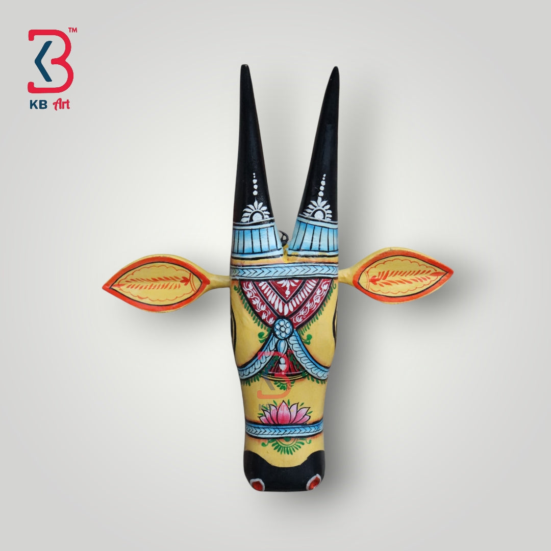 Hand-painted wooden bull mask in yellow and black with intricate floral patterns.