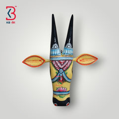 Hand-painted wooden bull mask in yellow and black with intricate floral patterns.