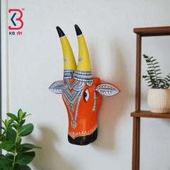 Artistic wooden bull head sculpture with black horns and a turquoise body, showcasing traditional Indian art.