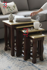 Three multi-size brass-fitted rectangular wooden side tables with curved legs arranged in a staggered step formation to highlight their graduating heights.