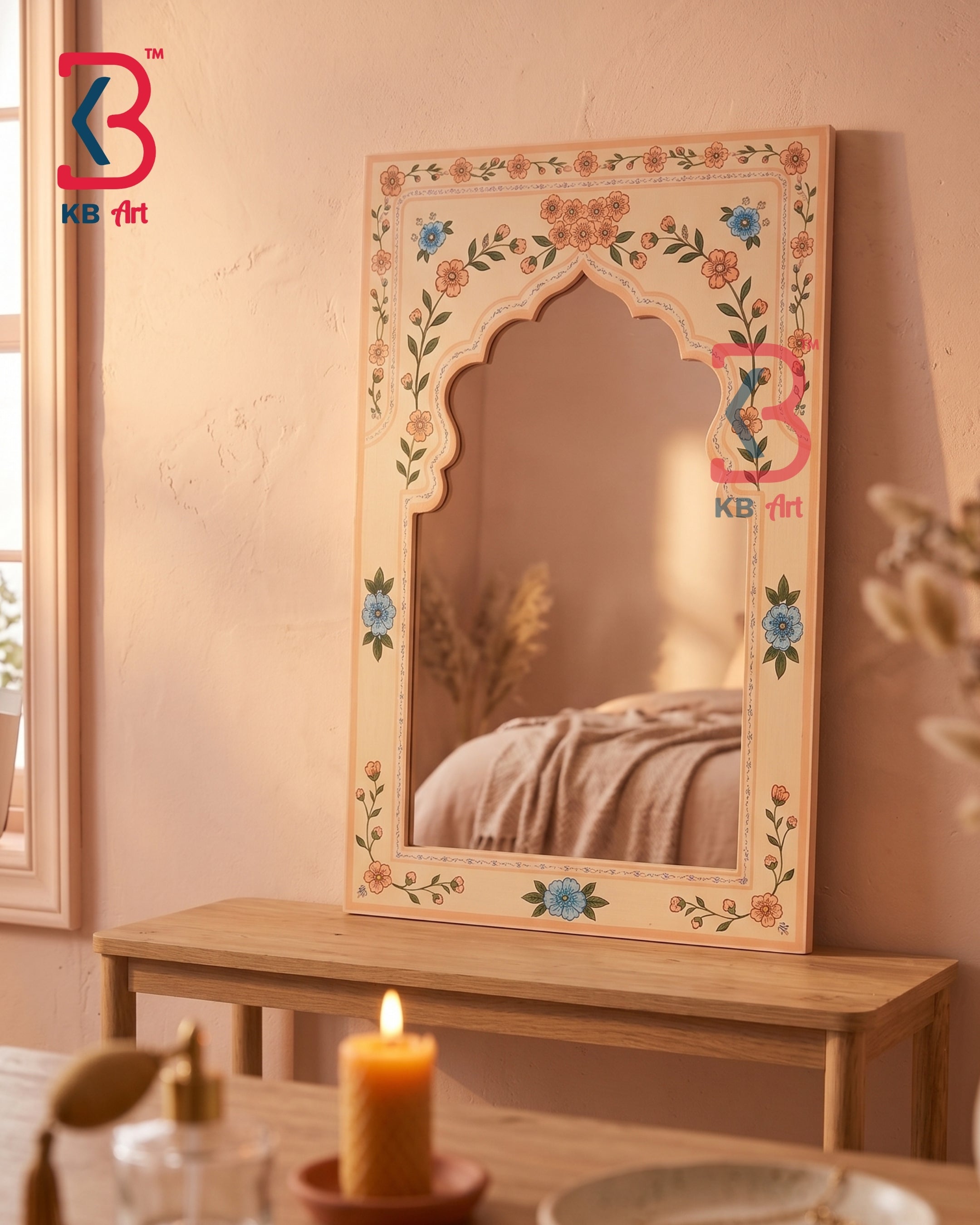 A decorative arched wall mirror with a cream-colored frame and hand-painted floral motifs in blue, orange, and green, displayed on a wooden console table in a warmly lit room.
