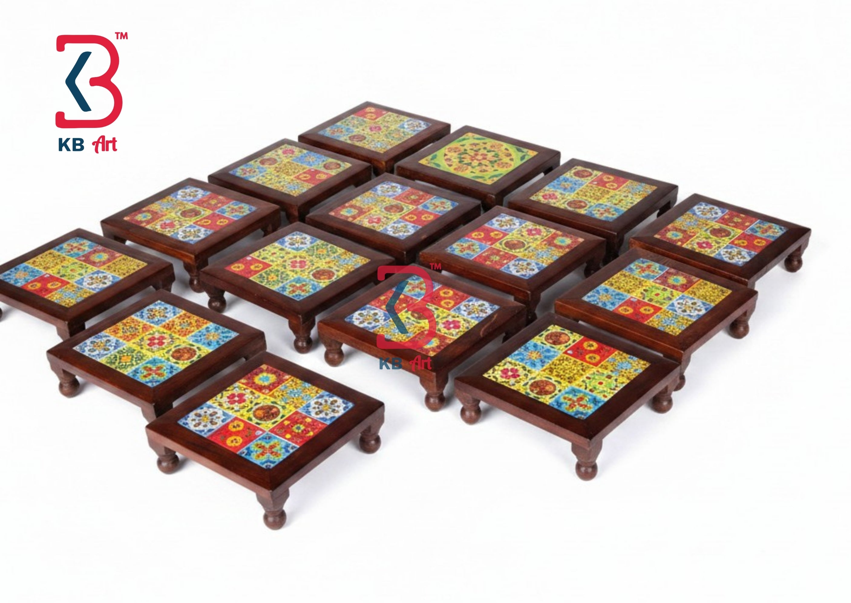 A set of small square wooden footstools or low tables with colorful mosaic tile tops, arranged on a plain white background. A KB Art logo is visible in the top-left corner.
