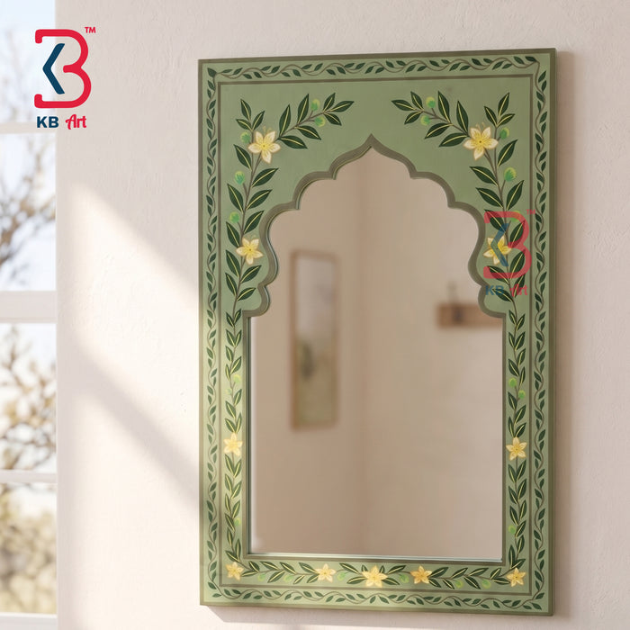 An arched decorative wall mirror with a painted green border featuring leafy vines and small yellow flowers, mounted on a light wall. A KB art logo appears in the top-left corner.