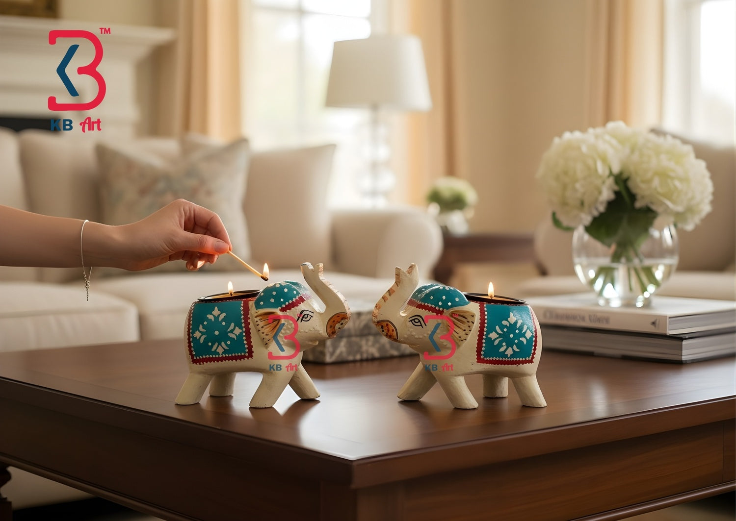 A pair of KB ART hand-painted elephant candle holders illuminating a beautifully styled home altar next to incense sticks and marigold flowers.