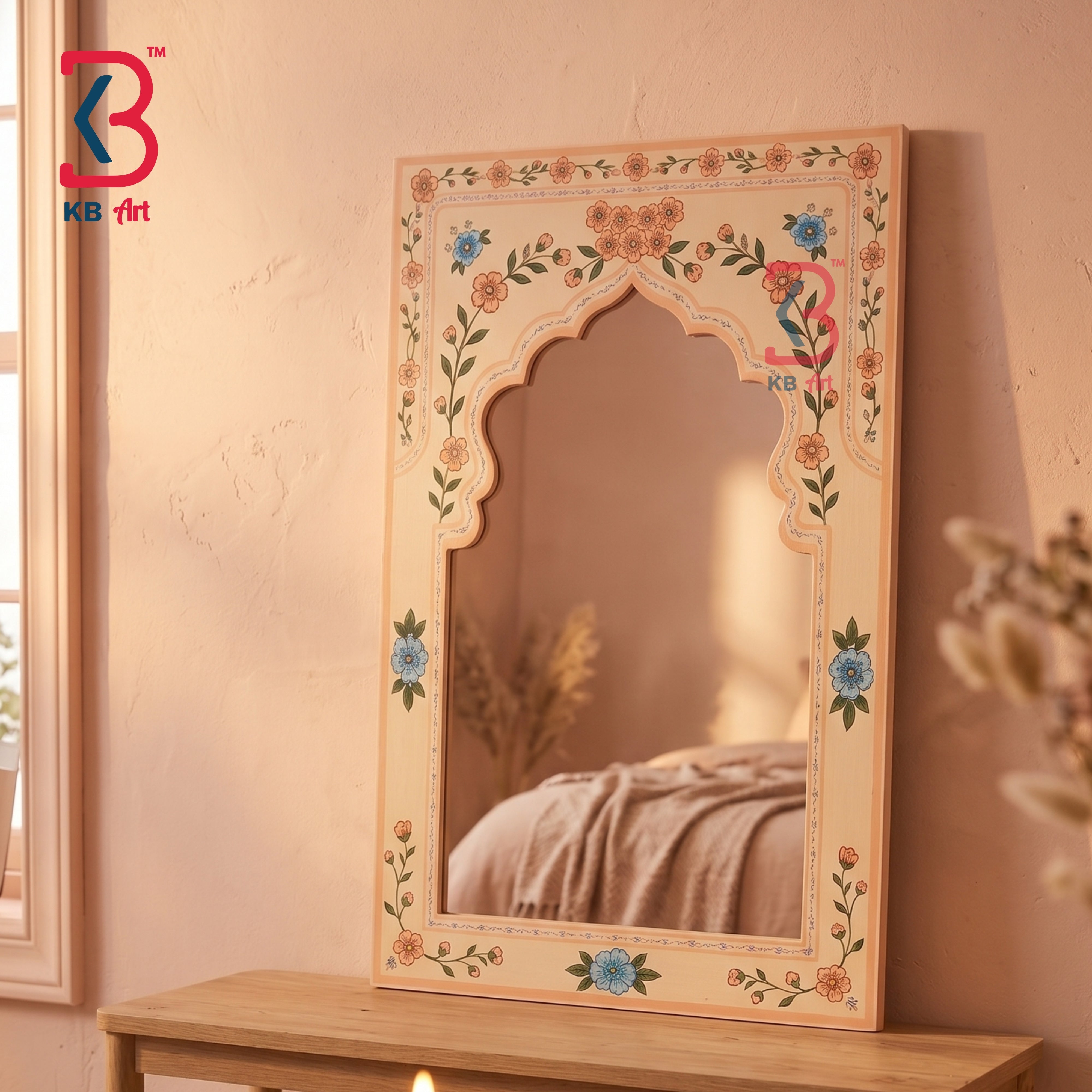 An ornate rectangular wall mirror with a scalloped arch top and hand-painted floral details in blue, orange, and green on a beige frame, leaning on a wooden table against a textured beige wall.