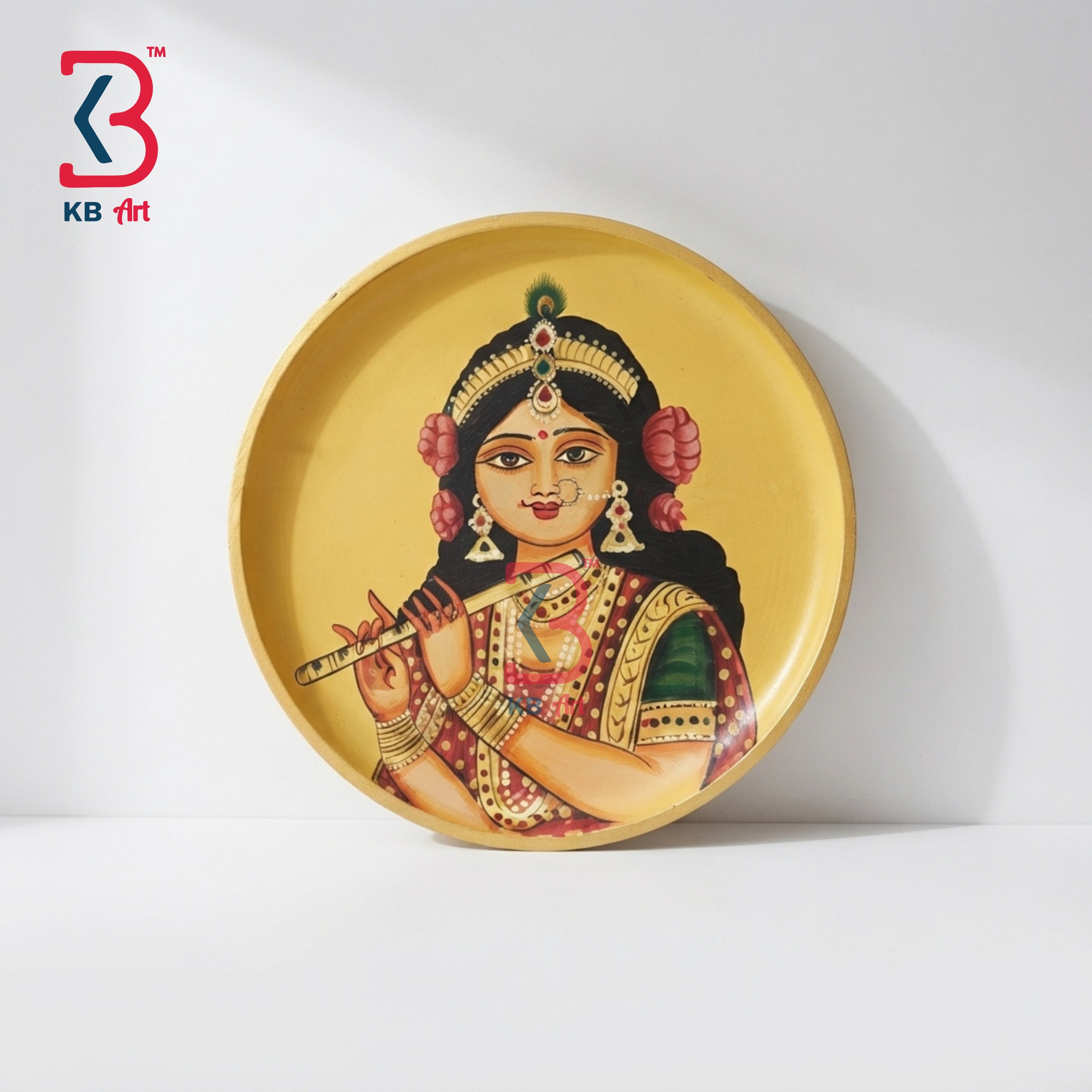 Handpainted wooden wall plate with Radha Rani flute artwork A round decorative plate featuring a painted illustration of a traditional Indian figure playing a flute, set against a warm gold background. The plate is photographed on a clean white surface with a soft shadow cast to the right.