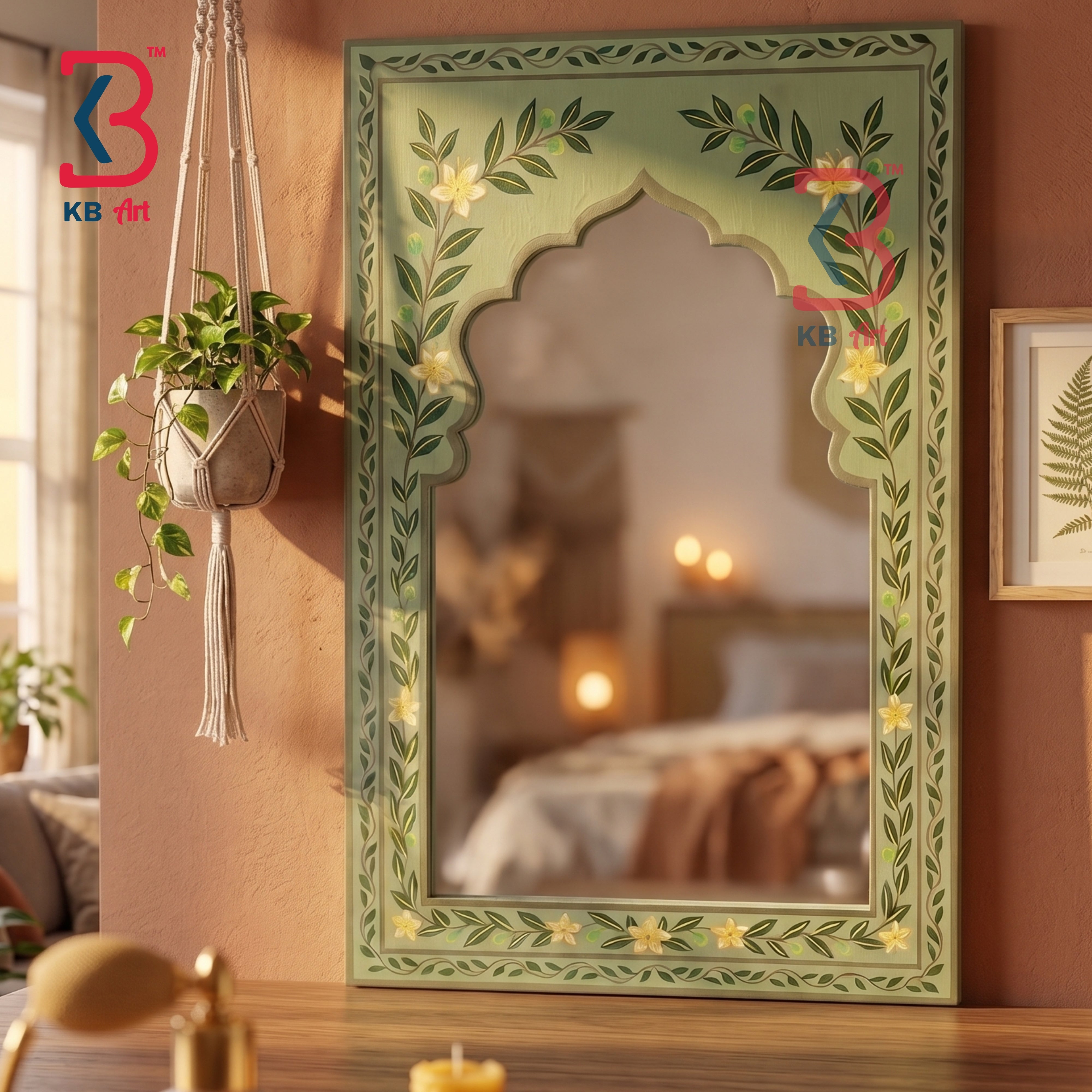A decorative arched mirror with a painted green frame featuring floral and leaf motifs, shown hanging on a warm brown wall in a styled interior setting.