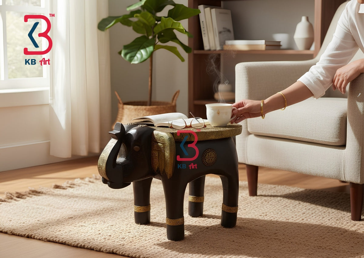 KB ART decorative hand-carved wooden elephant stool with an embossed golden brass sheet top, brass ears claddings, and dark wood legs on a clean white background.